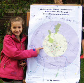Student pointing a map of the school with distances that students walked to school